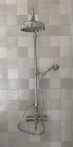 Professional Charlotte plumber installing a new shower and bathroom fixtures in modern remodel