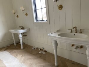 Charlotte plumber installing a cast iron double sink with widespread faucets