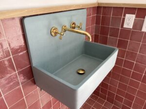Charlotte plumber installing a brass sink in a powder room