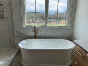 Charlotte plumber installing a freestanding bathtub and shower in a bathroom