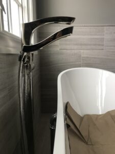 luxury freestanding tub filler installed with cast iron bathtub in custom bathroom